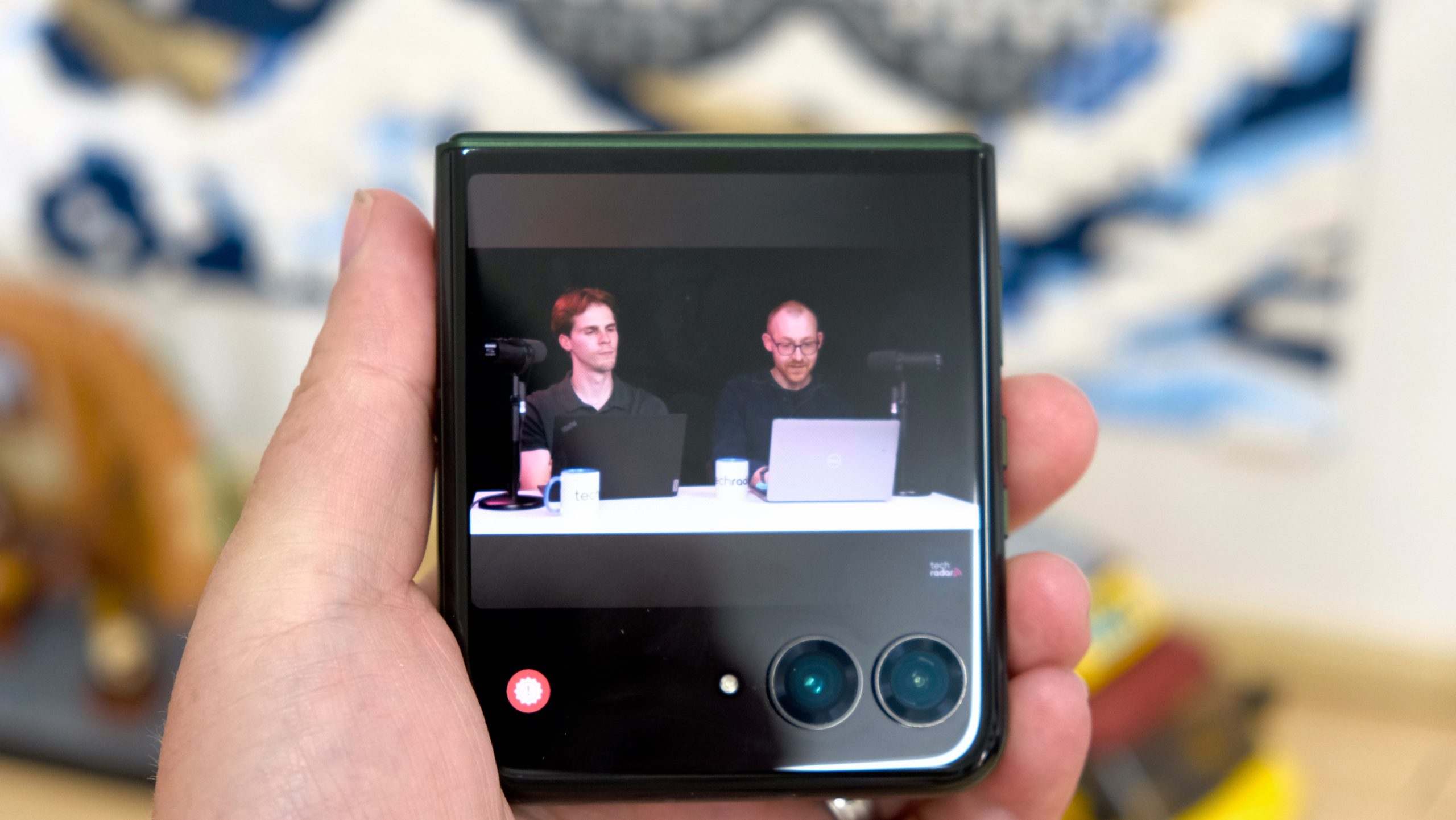 The Motorola Razr Plus 2026 in the hand and on a wooden table