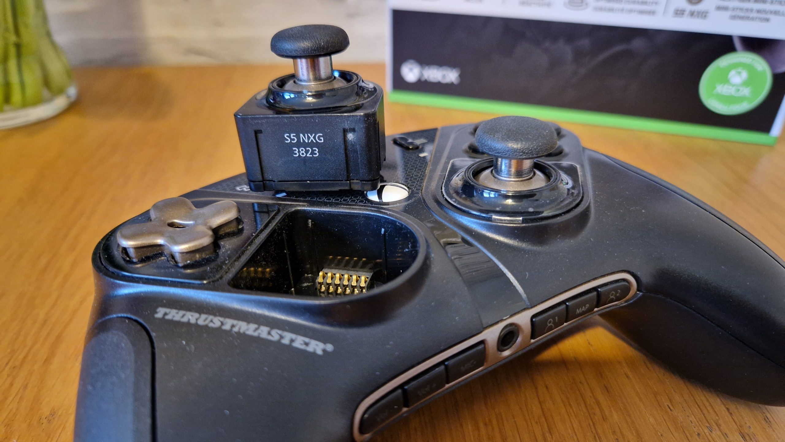 The Thrustmaster eSwap X2 controller on a wooden surface